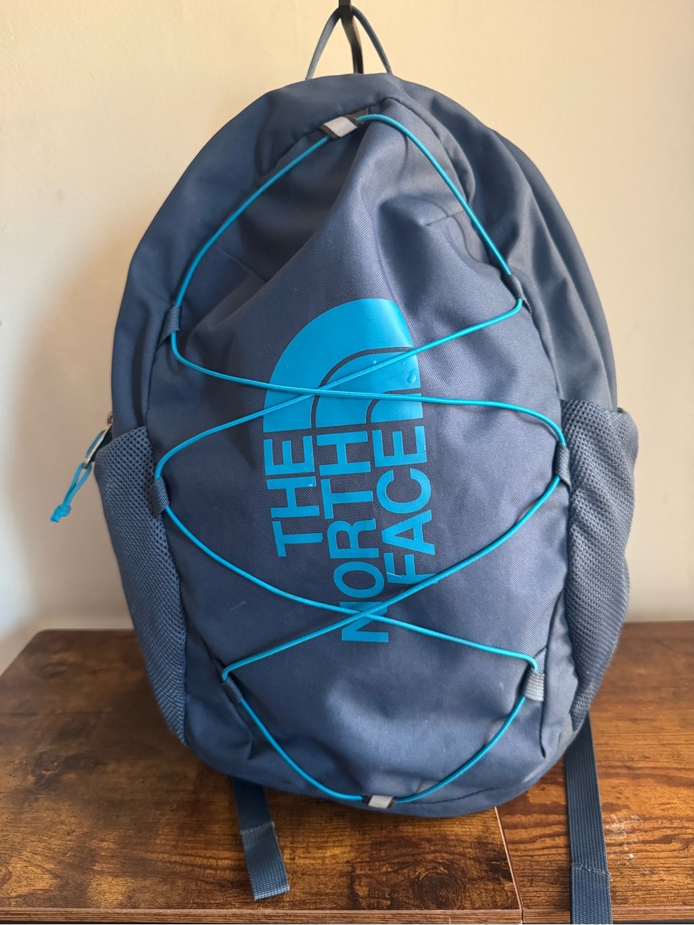 The North Face Men's Dark Blue Backpack with Teal Logo and Bungee